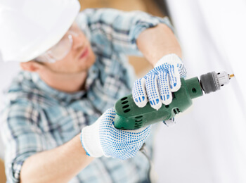 Technician using a drill providing maintenance services