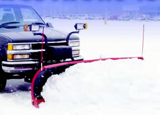 Truck with plow plowing snow in a parking lot